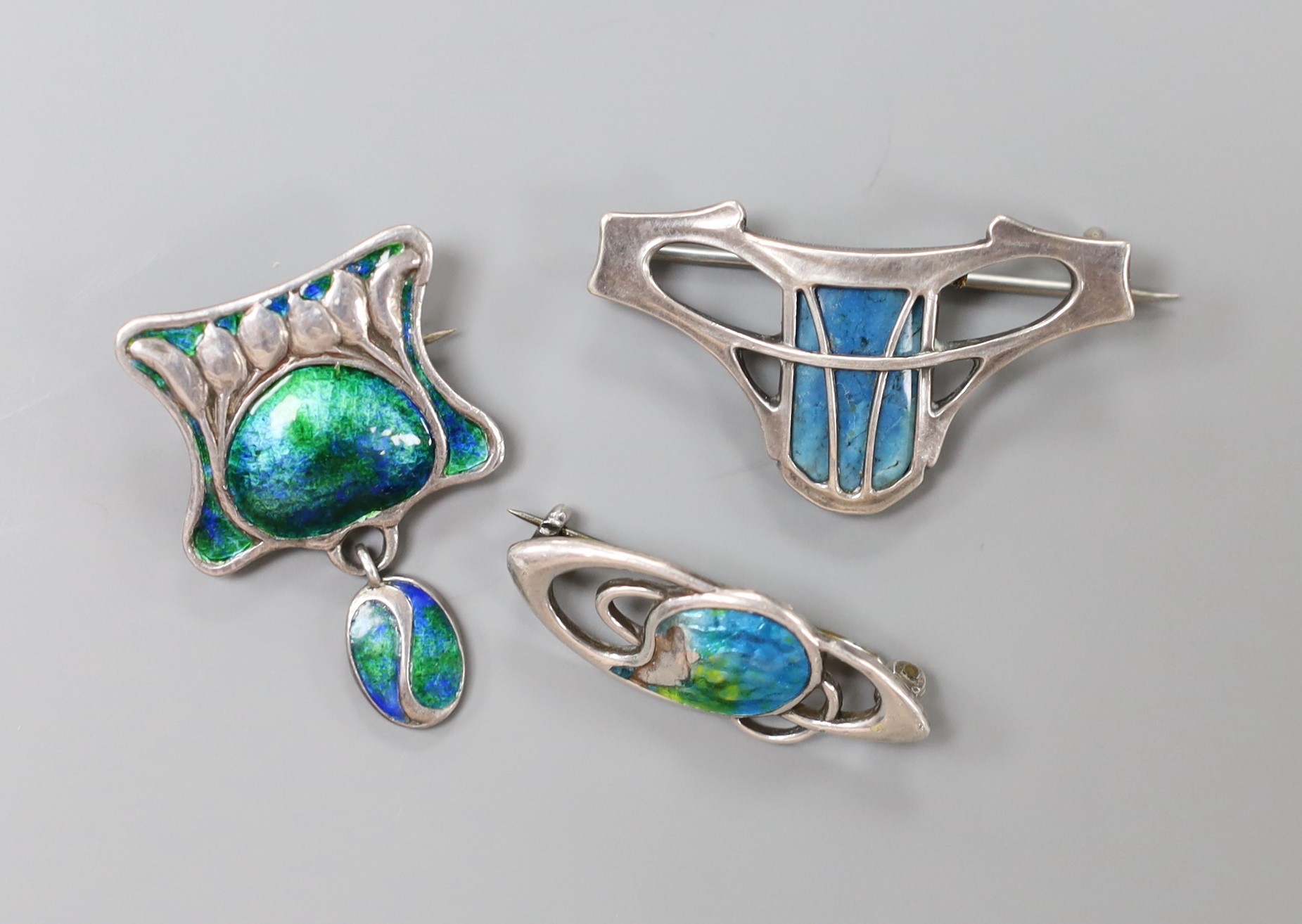 An early 20th century sterling and enamel set drop brooch, maker's mark only for William Hair Haseler, 33mm, a similar silver and enamel navette shaped brooch by Charles Horner and one other 800 white metal and enamel br